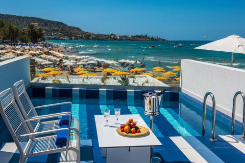 斯塔里斯I Resort Beach Hotel & Spa的海滩阳台上的一张桌子和一碗水果