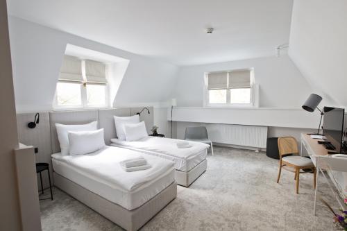 波兹南Port Sołacz的一间白色卧室,配有两张床和一张书桌