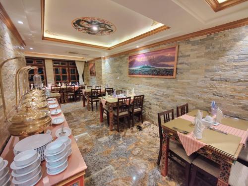 加德满都Sherpa Home Hotel的餐厅设有桌椅和盘子