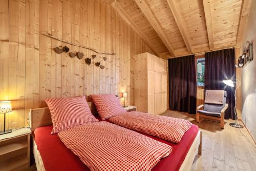 斯卢德尔诺Grushof App Köpfl的一间卧室配有一张带红色床单的床和一把椅子