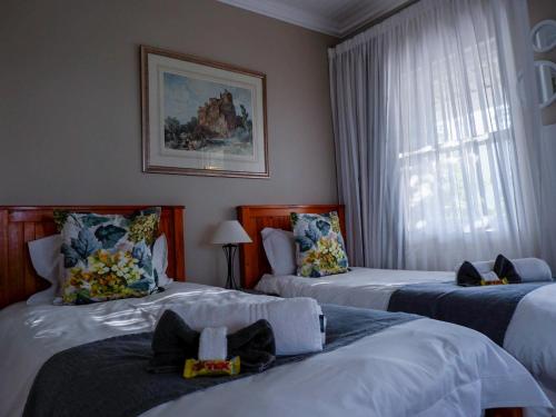 莫塞尔湾Authentic Mossel Bay的酒店客房设有两张床和窗户。