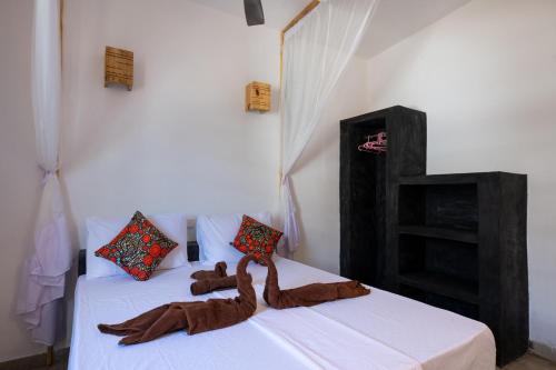 江比阿Nyumbani Residence Apartments的一间卧室配有两张带棕色毯子的床