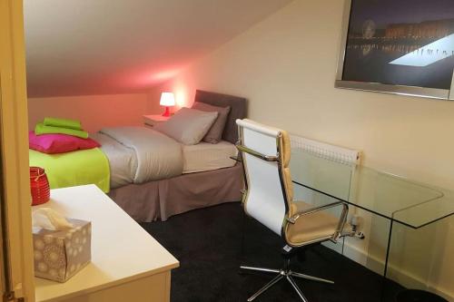 利物浦Large 6 bedroom duplex - perfect for large family的客房设有两张床、一张桌子和一把椅子。