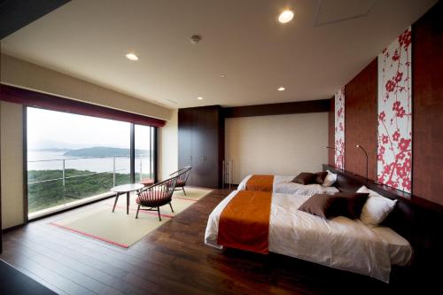 和歌山Kyukamura Kishu-Kada的一间卧室设有一张大床和一个大窗户