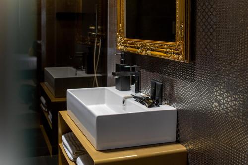 那不勒斯Plebiscito Boutique Rooms的浴室设有白色水槽和镜子