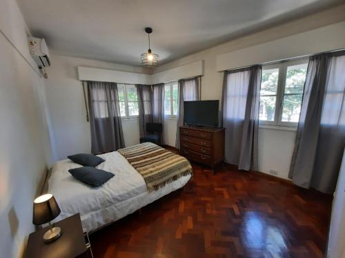 门多萨Departamento Mendoza的一间卧室配有一张床和一台平面电视