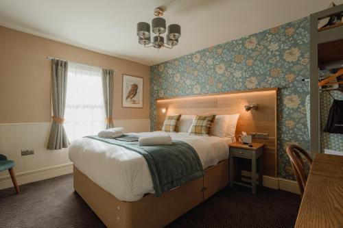 索利赫尔The Bell的一间卧室设有一张大床和一个窗户。