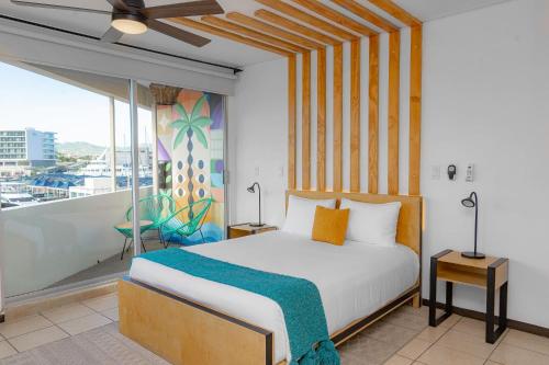卡波圣卢卡斯Mayan Monkey Los Cabos的一间卧室设有一张床和一个阳台