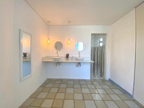 阿拉卡茹Exclusiva Casa na Melhor Praia de Aracaju的浴室设有两个盥洗盆和墙上的镜子