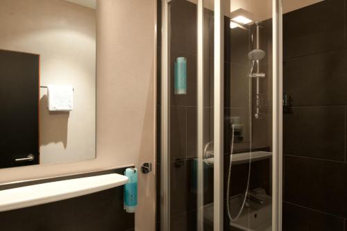 美因河畔法兰克福Hotel Topas Frankfurt City的浴室设有玻璃淋浴间和镜子