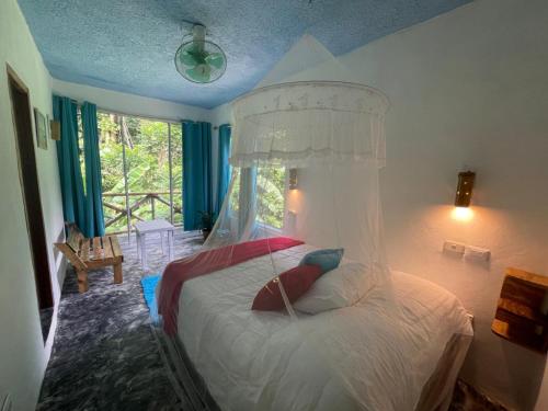 圣塔芭芭拉-山美纳Salvaje Rooms&Restaurant的一间卧室配有一张带天蓬的白色床