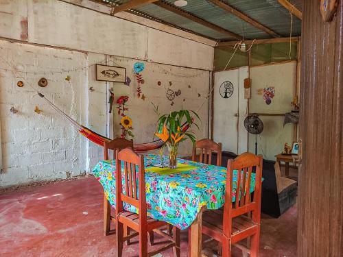 马尔多纳多港ROSA'S HOUSE的一间用餐室,配有桌椅和花瓶