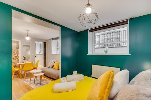 斯蒂夫尼奇Spacious Luxury Service Apartment Stevenage Town Centre family or business的客厅设有蓝色的墙壁和黄色的桌子