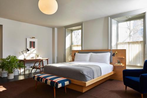 金斯顿Hotel Kinsley的一间卧室配有一张床、一张书桌和两个窗户。