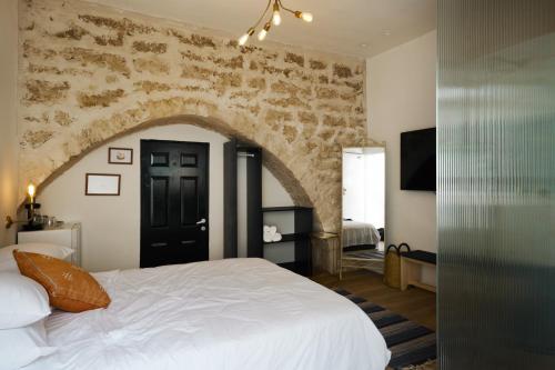 特拉维夫Tel-Aviv LALA Boutique Hotel的一间卧室设有一张带石墙的大床