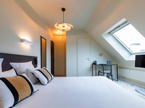 洛里昂MOKA Hôtel的卧室配有一张白色大床和天窗