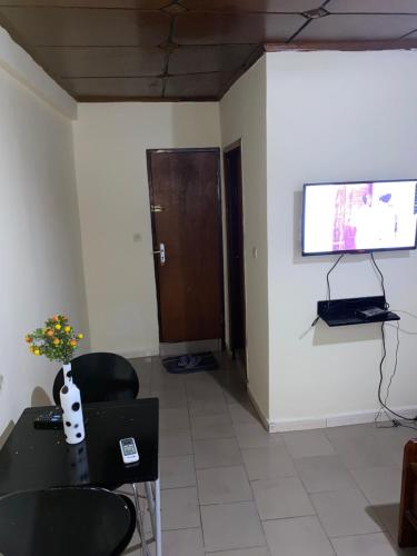 科纳克里Studio meublé à Conakry的配有桌椅和电视的客房