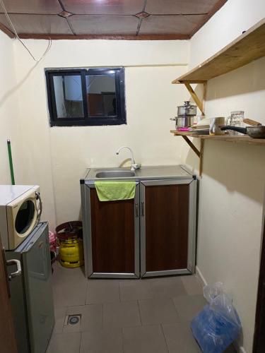 科纳克里Studio meublé à Conakry的一间带水槽和微波炉的小厨房