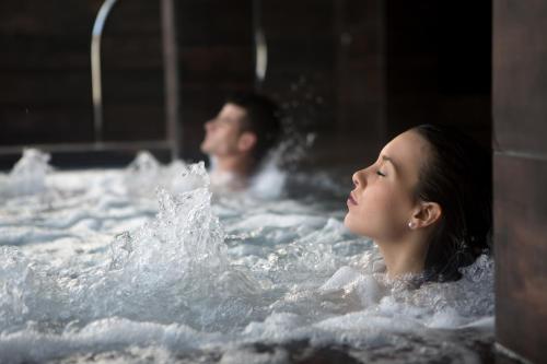 斯维诺乌伊希切海豚Spa别墅酒店的浴缸里的男人和女人