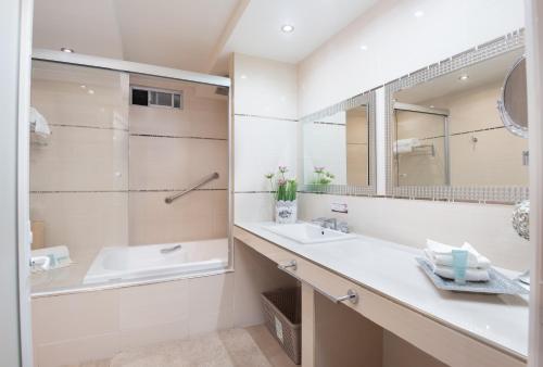 马特瓦拉Hotel del Parque的一间带水槽、浴缸和镜子的浴室
