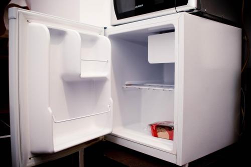 锡比乌Studio Leena的开放式的白色冰箱,门是敞开的