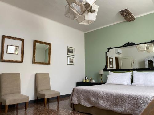 博洛尼亚BLQ 01精品住宿加早餐旅馆的一间卧室配有一张带两把椅子和镜子的床
