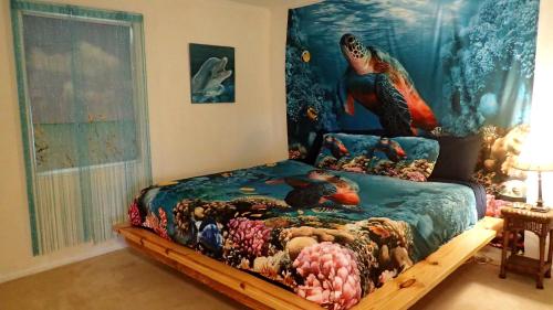 微风湾Reef Dreamer Artist’s Retreat的一间卧室配有一张美人鱼画床