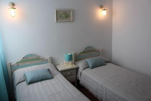 卡兰博希Precioso apartamento en complejo con piscina的配有2张单人床的客房,配有2盏灯