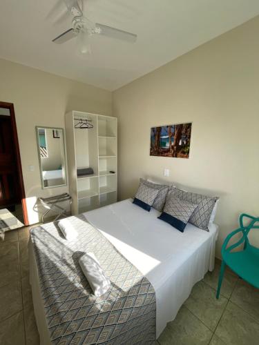 乌巴图巴Pousada Serrate的卧室配有一张白色大床和风扇