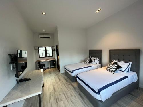 沙湾拿吉Macchiato Resort Savannakhet Opposite Thai Embassy的酒店客房设有两张床和一张桌子。