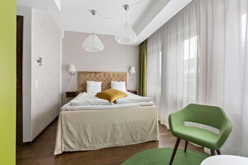 奥克什贝里亚Best Western Hotel Akersberga的一间卧室配有一张床和一把绿色椅子