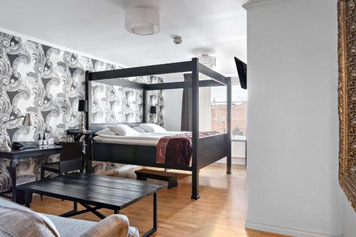 维斯比Donners Hotell的一间卧室配有一张天蓬床和一张桌子