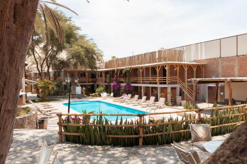 伊察埃尔华卡其内罗酒店的一个带游泳池和椅子的度假胜地和一座建筑