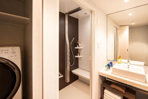 东京karaksa hotel colors Tokyo Yaesu的带淋浴、盥洗盆和镜子的浴室