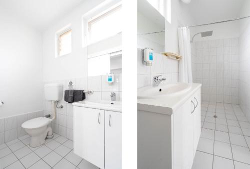阿德莱德市西汽车旅馆的白色的浴室设有水槽和卫生间。