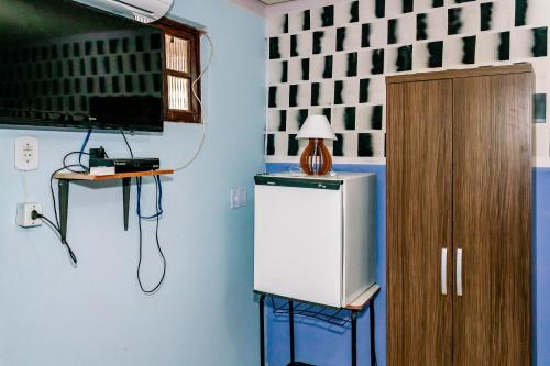 帕尔梅拉斯Pousada Cachoeira da Fumaça的客房设有电视和小冰箱。