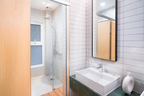 胡志明市Grandma Lu Saigon Hostel - Japan Town的白色的浴室设有水槽和淋浴。