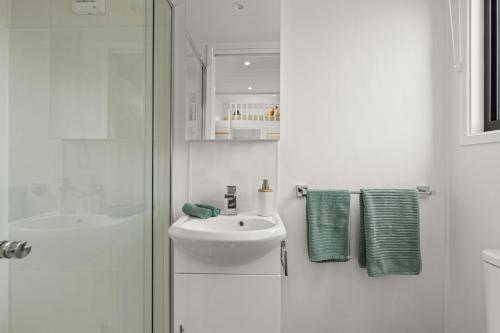 赫斯基森Husky Tiny Home by Experience Jervis Bay的白色的浴室设有水槽和淋浴。