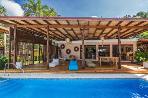 塔马林多Hotel Arco Iris的房屋旁的木甲板,设有游泳池