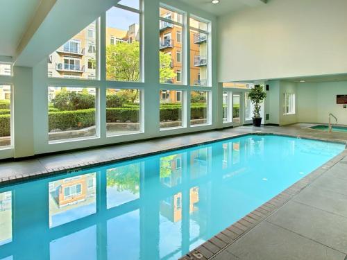 西雅图City Water View Oasis with Pool & Gym near Cruise in Heart of Seattle的一座带窗户的建筑中的游泳池