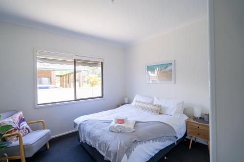 斯旺西Lakeside dream的一间卧室设有一张床、一个窗口和一把椅子
