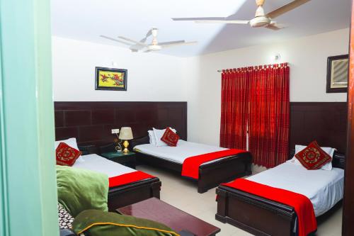 达卡Ali International Hotel的一间卧室配有两张红色和绿色床单的床