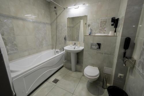 库斯塔奈BANQUETING & GUEST HOUSE ПОМЕСТЬЕ的一间带水槽、浴缸和卫生间的浴室