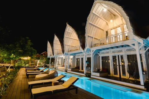 珀尼达岛Mambo Beach Resort的夜间带游泳池的度假村