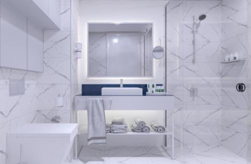 巴统Batumi Inn Aparthotel With Sea View的白色的浴室设有水槽和镜子