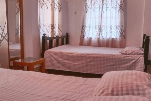 巴纳内拉斯Ashiana Serviced Apartment的一间卧室配有两张床、镜子和镜子