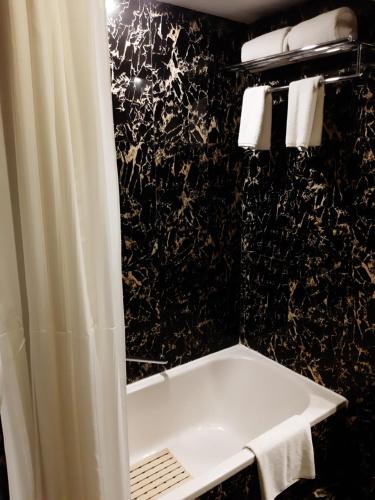 班加罗尔Trinity Hotel Bengaluru的一间带白色淋浴帘的浴室