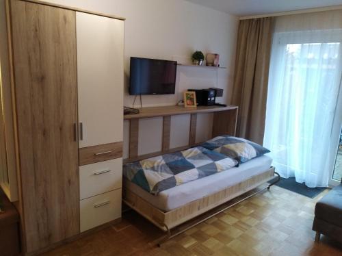 埃尔策Ferienwohnung Leinetal的一间卧室配有一张床和一个带电视的橱柜
