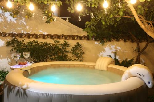 蒙萨拉什A Janela Do Castelo的花园内的热水浴池,配有桌子和酒杯