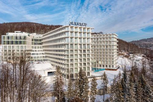 维斯瓦Crystal Mountain Hotel Wisła的一座大建筑,上面有标志